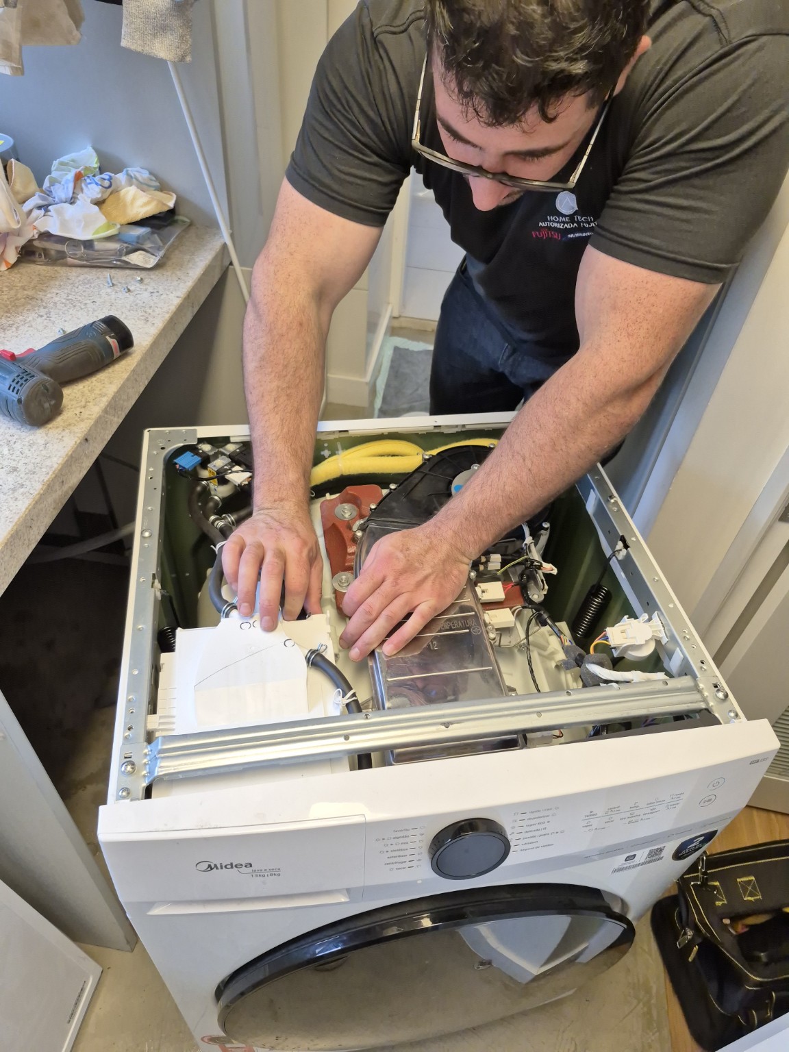 Técnico realizando manutenção em equipamento de lavanderia